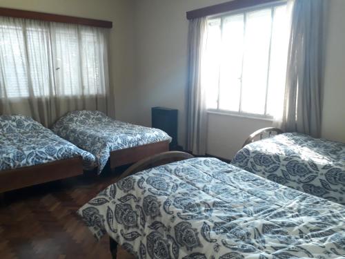 Habitación con 3 camas en una habitación con ventanas en Mendoza - Casa Cardozo en Guaymallén