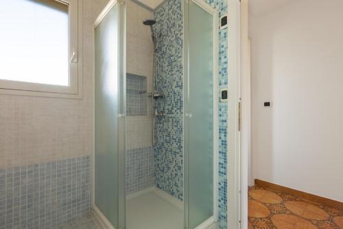 a shower with a glass door in a bathroom at Appartamento Giade by BarbarHouse in Torre dell'Orso