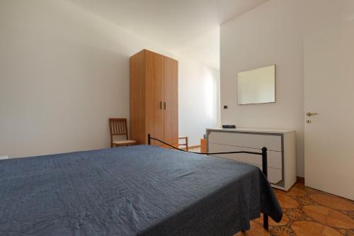 a bedroom with a bed and a desk and a cabinet at Appartamento Giade by BarbarHouse in Torre dell'Orso