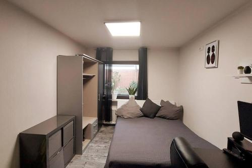 een kleine kamer met een bed en een raam bij Superior Haus 120 qm mit Garten in Düsseldorf