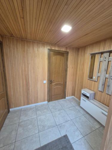 an empty room with a wooden ceiling and a door at Namas Zarasuose su vyno rūsiu in Zarasai