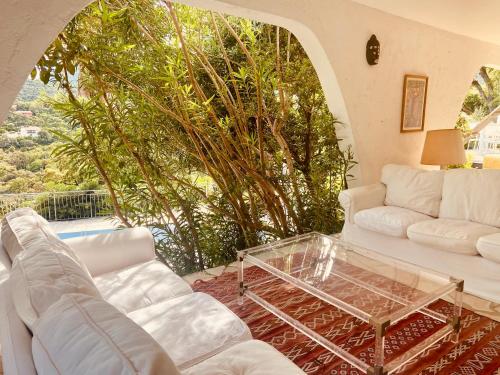 sala de estar con sofás blancos y mesa de cristal en Villa Hirondelles 35, en Cavalaire-sur-Mer