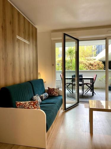 un salon avec un canapé vert et une table dans l'établissement Appartement Keywest - centre ville, à Andernos-les-Bains