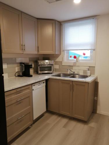 a kitchen with wooden cabinets and a sink and a window at Luxury Style Hotel Living in Chatham