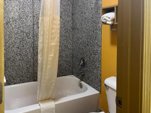 La salle de bains est pourvue d'une baignoire blanche et de toilettes. dans l'établissement Motel 6 Morrilton, AR, à Morrilton