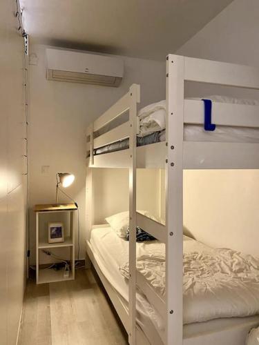 une chambre avec deux lits superposés et une lampe dans l'établissement Appartement Keywest - centre ville, à Andernos-les-Bains