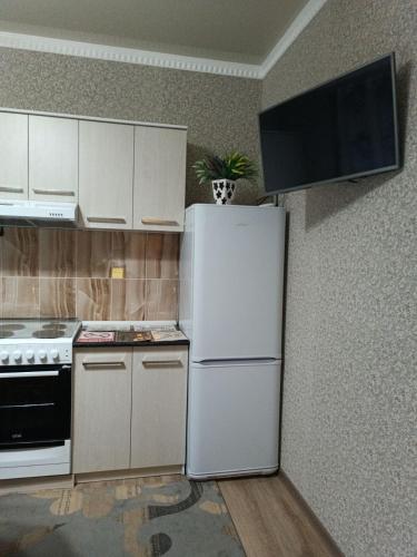 a kitchen with a white refrigerator and a stove at Oskar in Toktogul