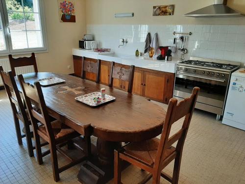 - une cuisine avec une table en bois, des chaises et une cuisinière dans l'établissement Gîte tout inclus avec parc, proche de Joinville, pour 10 personnes et activités variées - FR-1-611-102, à Bettaincourt-sur-Rognon