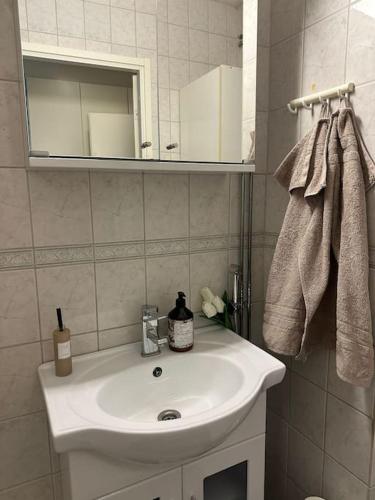 W łazience znajduje się biała umywalka i lustro. w obiekcie Stunning city center studio with balcony 37 m2 w mieście Lappeenranta
