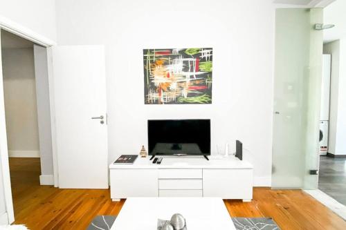 a living room with a white cabinet and a painting on the wall at HU2i - In&Out Sete Rios in Lisbon