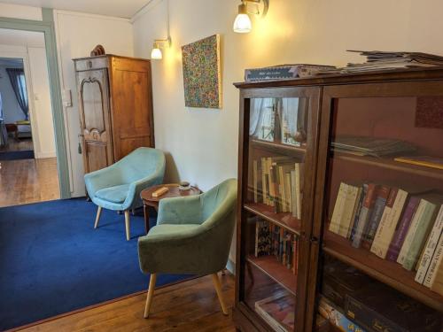 - un salon avec deux chaises et une étagère dans l'établissement Gîte cosy avec jardin clos, terrasse et piscine à proximité, idéal pour famille et détente - FR-1-653-254, à Châteauneuf-sur-Charente