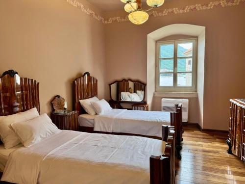 Una cama o camas en una habitación de Olea Apartments in a Historic 17th Century Palace Perast
