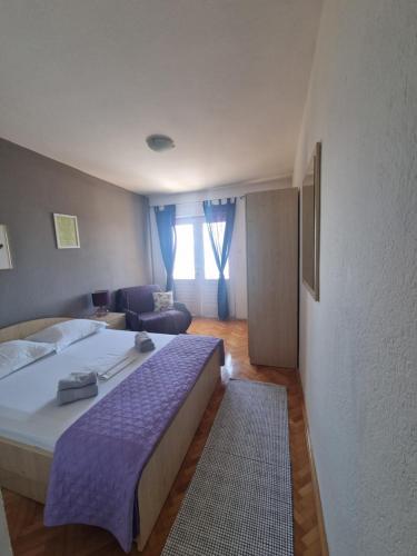 a bedroom with a large bed and a living room at Podgora apartment no.5 in Podgora