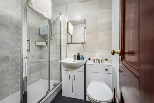 y baño con aseo, lavabo y ducha. en Caledonia Suite - Netflix Free Parking en Glasgow