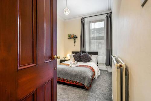 a small bedroom with a bed and a window at Caledonia Suite - Netflix Free Parking in Glasgow