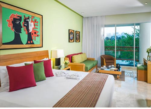 a bedroom with a bed and a living room at Vidanta Riviera Maya in Puerto Morelos
