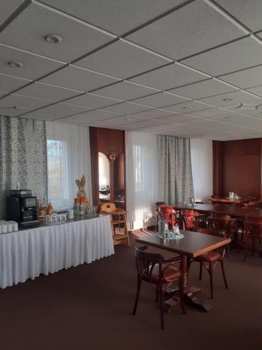 a dining room with tables and chairs and tablesearcher at Hotel zum Mückenberger Hof in Lauchhammer