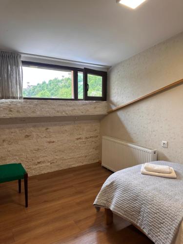 a bedroom with a bed and a window at Bala's House in Mestia