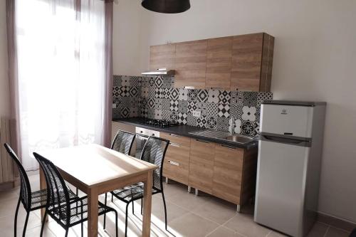 une cuisine avec une table, des chaises et un réfrigérateur dans l'établissement Beau T1, agréable à vivre, à Limoges