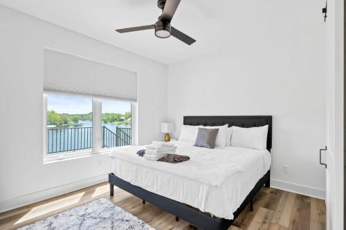 a white bedroom with a large bed and a window at Grant's Point Lake House in Williamstown