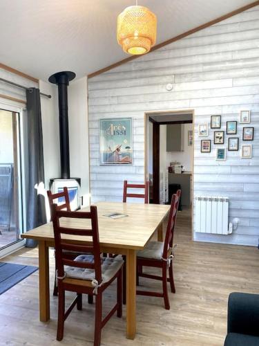 une salle à manger avec une table et des chaises en bois dans l'établissement Maison (4pers) confortable entre bassin et océan, à Arès