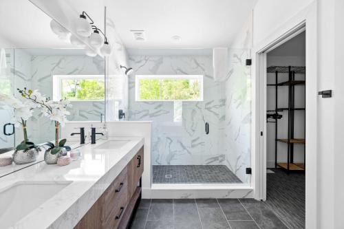 baño blanco con ducha y lavamanos en Grant's Point Lake House, en Williamstown