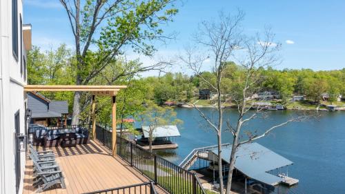 a house with a deck with a boat in the water at Grant's Point Lake House in Williamstown