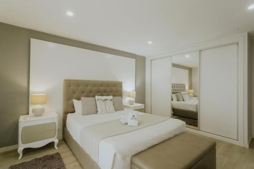 Un dormitorio blanco con una cama grande y un espejo. en Best Houses 107 - Ferrel Village House, en Ferrel