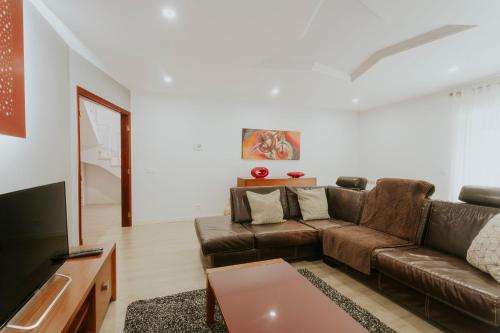 a living room with a brown couch and a tv at Best Houses 107 - Ferrel Village House in Ferrel
