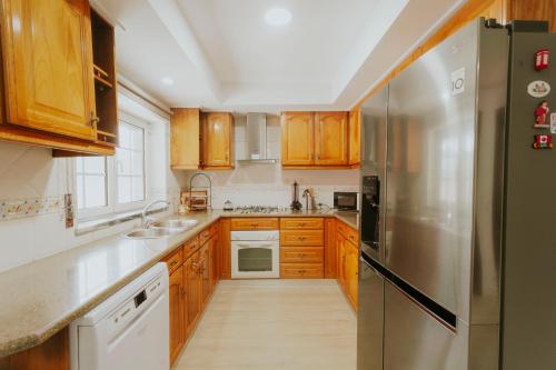 a kitchen with wooden cabinets and a stainless steel refrigerator at Best Houses 107 - Ferrel Village House in Ferrel