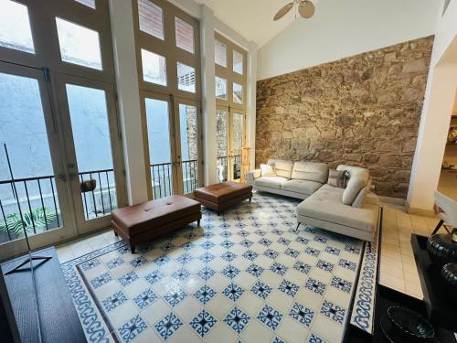 een woonkamer met banken en een stenen muur bij Best Location - Beautiful and Amazing Loft in Panama-Stad