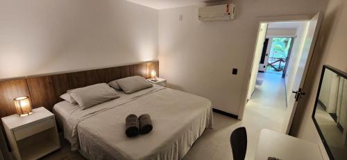 - une chambre dotée d'un lit avec une paire de chaussures dans l'établissement Flat Moderno Pé na Areia no Cumbuco Piscina e Localização Perfeitas Eco Paradise, à Caucaia