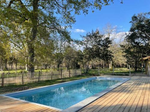 a swimming pool in a yard next to a fence at Cabane de Pêcheurs Huraia in Vielle-Saint-Girons