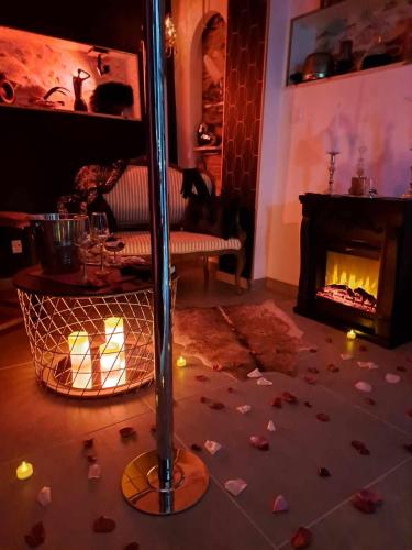 - un salon doté d'une table avec des bougies et d'une cheminée dans l'établissement Love room - Les Secrets du Château, à Château-Guibert