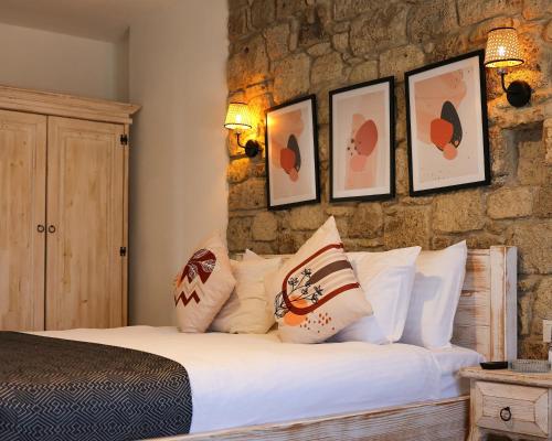 a bedroom with a bed with pillows and a stone wall at Lulja Alaçatı - Adults Only in Izmir