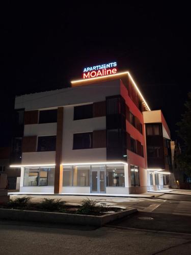 a building with a sign on top of it at night at Moaline Apartments, free parking in Sarajevo