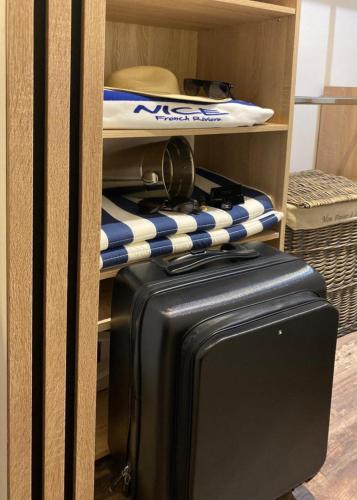une valise et une planche de surf sur une étagère dans l'établissement Denis&kanya, à Nice