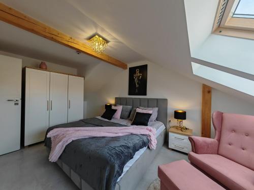 1 dormitorio con 1 cama y 1 silla rosa en Villa Lamar, en Międzyzdroje
