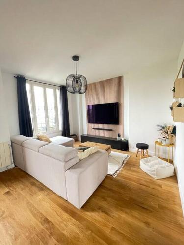 - un salon avec un canapé blanc et du parquet dans l'établissement Appartement chaleureux proche Paris JO 2024, à Saint-Gratien
