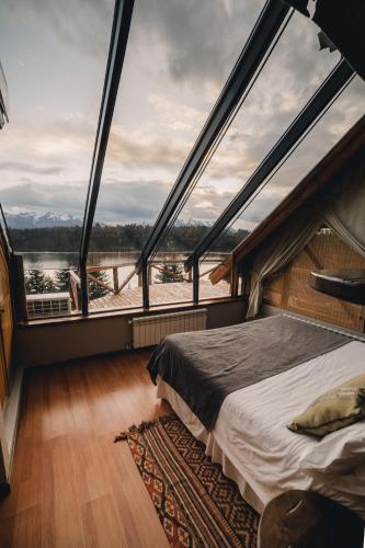 a bed in a room with a large window at Marinas Alto Manzano in Villa La Angostura