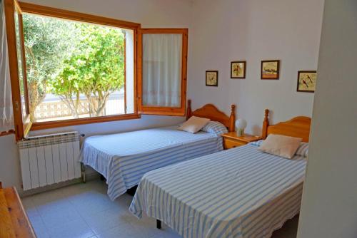 ViladamatにあるCasa en Viladamat con piscina en la Costa Bravaの窓付きの部屋 ベッド2台