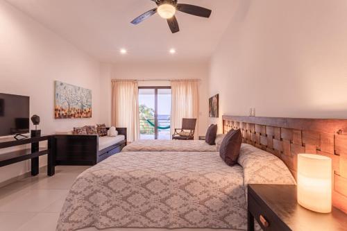 - une chambre avec 2 lits et un ventilateur de plafond dans l'établissement Villa Bellamar : A dream beachfront spot near Tulum with Chef Service included, à Akumal