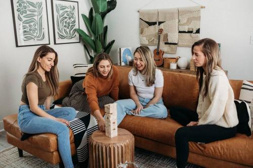 three girls are sitting on a couch at Boho Haven Hideaway - Walk to Pool,Theater,Arcades, Firepit, Lake Access in Thornhurst
