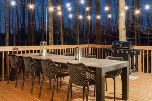 a table and chairs on a deck with a grill at Boho Haven Hideaway - Walk to Pool,Theater,Arcades, Firepit, Lake Access in Thornhurst