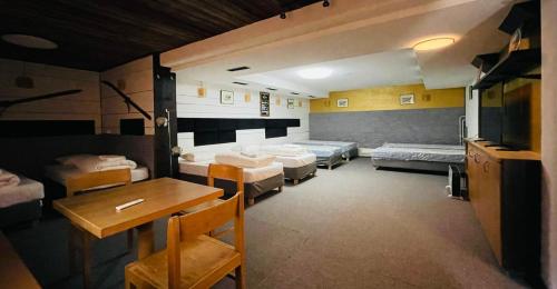 a room with four beds and a table and a dining room at Sternen B&B & Italienisches Restaurant in Elm