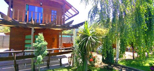a wooden house with a fence in front of it at Cabañas con Tinaja 4 a 6 personas in Quillón
