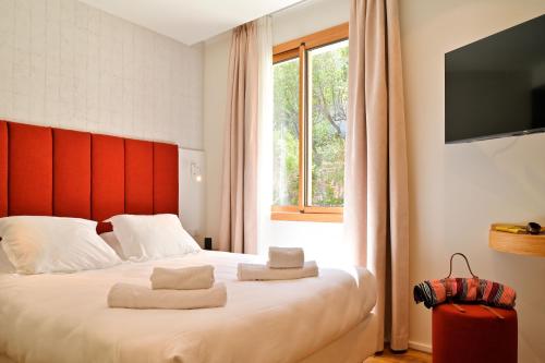 a bedroom with a bed with a red headboard and a window at HOTEL SAINT ROCH in Ogliastro