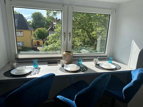 une table à manger avec deux chaises et une grande fenêtre dans l'établissement Apartment- La Mia, à Castrop-Rauxel