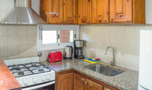 a kitchen counter with a stove and a sink at Cabañas Mellmell in Mar de las Pampas