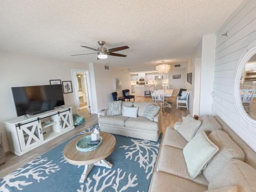 a living room with a couch and a tv at Luxury, Direct Oceanfront Unit and Balcony, Northeast Corner, Heated Pool, Garage Parking in Ormond Beach